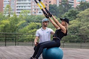 a personal trainer and a woman having workout outdoors